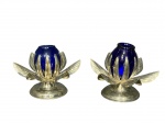 METAL PRATEADO e VIDRO, par (2) de castiçais confeccionados em metal espessurado a prata da manufatura EBERLE cinzelado por folhagens e recipientes em vidro na tonalidade azul, medindo 7cm e 7,5cm.