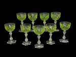 CRISTAIS, nove (9) taças para vinho confeccionadas em cristal na tonalidade verde uralina com lapidação de formas ovais em baixo relevo, haste translucida facetada em balauste e base sextavada ao gosto Baccarat, medindo 12x6,5cm.