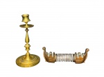 BRONZE e METAL COBREADO, lote com duas (2) peças, sendo: A) 1 castiçal confeccionado em bronze com corpo torneado, apoiada sobre base circular escalonada, apresentando mossa na bobeche, medindo 22,5cm e B) 1 porta guardanapos no feitio de embarcação em metal cobreado com corpo em molas, medindo 7,5x21cm, sinais de oxidação.