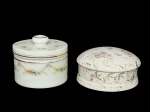 PORCELANA e OPALINA, lote com duas (2) caixas porta joias, sendo: A) 1 confeccionada em OPALINA na tonalidade branca, decorada por guirlanda floral em policromia e filetes em ouro, apresentando falhas na douração, medindo 10x11,5cm e B) 1 confeccionada em porcelana da manufatura SALER, ricamente decorada por rosáceas e folhagens em policromia e elementos vegetalistas em vasta douração com falhas na douração, medindo 7x12,5cm.