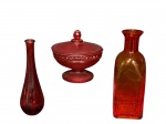 VIDROS, lote com três (3) peças confeccionadas em vidro na tonalidade vermelha de modelos, tamanhos e decorações distintas, sendo: A) 1 bomboniere pintada com moldagem em bico de jaca, medindo 13x13cm, falhas na pintura, B) 1 vaso solifleur pintado, apresentando falhas na pintura, medindo 18cm e C) 1 vaso no feitio de garrafa, medindo 20cm de altura.