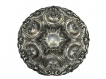 METAL PRATEADO, um (1) medalhão confeccionado em metal espessurado a prata com rico cinzelado de volutas, concheados, flores, folhagens e arabescos relevados com recortes na borda, apresentando leves falhas na prateação e pequena falha no metal, medindo 44cm de diâmetro.