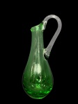 MURANO, uma (1) jarra confeccionada em vidro de Murano na tonalidade verde com alça translucida em vazado, medindo 23cm de altura.