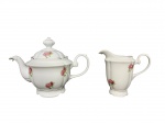 PORCELANAS, duas (2) peças, sendo: A) 1 bule para chá, medindo 19x26x15cm e B) 1 leiteira, medindo 15x16x9,5cm, confeccionadas em porcelana na tonalidade branca, decorada por flores e folhagens em policromia e filetes em ouro.