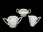 Fábrica de Porcelana da Vista Alegre, ílhavo - Portugal (Fundada em 1824 por José Ferreira Basto), três (3) peças confeccionadas em porcelana portuguesa na tonalidade, sendo: A) 1 açucareiro sextavado sem tampa, medindo 9x18x9cm, B) 1 leiteira sextavada, medindo 10x12x6,5cm, bicado na base, e C) 1 açucareiro sem tampa com borda filetada em ouro, medindo 8x16,5x8,5cm, bicado na borda.
