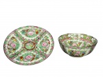 PORCELANA ORIENTAL, lote com duas (2) peças, sendo; A) 1 prato decorativo, medindo 20cm e B) 1 tigela, medindo 7x15cm, confeccionadas em porcelana branca ao gosto Familia Rosa, decorado por elementos florais e vegetalistas em policromia com realces em ouro.