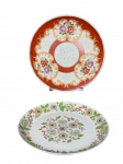 PORCELANAS, dois (2) pratos decorativos confeccionados em porcelana branca com pintura floral de modelos distintos em policromia, sendo 1 da manufatura SCHMIDT e 1 de origem oriental, medindo 25cm e 26cm, apresentando falhas na douração.