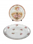 PORCELANAS, duas (2) peças, sendo: A) 1 prato decorativo adaptado para relógio de parede confeccionado em porcelana com pintura floral em policromia, algarismos romanos, falta ponteiros, maquinário no estado, medindo 20cm e B) REAL, 1 prato para bolo confeccionada em porcelana nacional na tonalidade branca com pintura floral em policromia e filete em ouro, medindo 26cm.