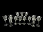 VIDROS, treze (13) taças para vinho de dois tamanhos confeccionadas em vidro translucido com lapidação geométrica e frisos em baixo relevo, haste cilíndrica apoiada sobre base circular, 3 apresentam ínfimos bicados, medindo 17,5x9cm e menor 15,5x8cm.