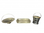 METAL PRATEADO, lote com três (3) peças, sendo: A) 1 bandeja retangular confeccionada em metal espessurado a prata com cinzelado de elementos vegetalistas e caneluras, leves falhas na douração, medindo 33x14cm, B) 1 fruteira no feitio de cesta confeccionada em metal espessurado a prata decorada em gomos torcidos com cinzelado floral em vazado, medindo 19x25cm e C) 1 balde para gelo confeccionado em metal prateado decorado por faixas horizontais em relevo, medindo 14x13cm.