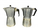 METAL PRATEADO, duas (2) cafeteiras italianas confeccionadas em alumínio com isoladores em plástico preto, ambas com sinais de uso e 1 possui furo no fundo, medindo 28x21x12cm.