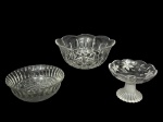 CRISTAIS, lote com três (3) peças confeccionadas em cristal translucido de modelos, tamanhos e decorações distintas, sendo: A) 1 tigela com lapidação de caneluras, espessa faixa em perolados e bico de jaca com arabescos relevados, medindo 7x17cm, B) 1 saladeira com lapidação geométrica e sulcos em baixo relevo com bordas em ondulações, medindo 10x22,5cm e C) 1 uveira de pé com lapidação de guirlanda de cachos de uva e folhas de parreira e pé gomado em tom fosco, medindo 10x14cm.