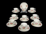 PORCELANAS, nove (9) xícaras para café com seus respectivos pires confeccionadas em porcelana na tonalidade branca com pintura de rosáceas e folhagens em policromia com borda filetada em ouro, medindo 5,5x7x5,5cm. 1 possui fio de cabelo.