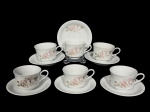 PORCELANA SCHMIDT, seis (6) xícaras para chá com seus respectivos pires confeccionados em porcelana nacional na tonalidade branca com pintura de flores e folhagens em policromia, medindo 6,5x11x8,5cm.