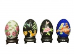 PORCELANA ORIENTAL, quatro (4) ovos decorativos confeccionados em porcelana oriental na tonalidade branca de decorações florais/pássaros em policromia, apoiados sobre peanha em madeira, medindo 7,5cm de altura com a peanha.