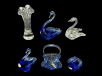 MURANOS, lote com seis (6) peças confeccionadas em vidro de Murano, sendo: A) trio de cisnes na tonalidade azul com selo da cristaleria COOPERCRISTAL, medindo 11,5cm, 8cm e 6cm, B) 1 cisne translucido, medindo 9x8x6,5cm, C) 1 pequena cesta decorativa na tonalidade azul, om selo da cristaleria COOPERCRISTAL, medindo 9x6,5x6,5cm e D) 1 floreira translucida com borda em babados, medindo 13,5cm de altura.