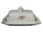 KPM Krister Porzellan-Manufaktur (Fundada em 1831 por Carl Franz Krister), uma (1) manteigueira, confeccionada em porcelana polaca na tonalidade branca com pintura de flores e folhagens em policromia com filetes em ouro, medindo 8,5x17x14,5cm.