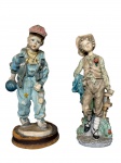 ESCULTURAS, duas (2) esculturas confeccionadas em resina italiana, sendo 1 representando menino com trajes de época e elementos florais em relevo e policromia e 1 representando menina com traje jeans, segurando bola e com chapéu na cabeça, esmaltada em policromia, apoiada sobre base em mdf no estado, medindo 21cm.