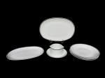 PORCELANA RENNER MEDAILLON, seis (6) peças, sendo: A) 2 travessas ovais, medindo 33x22cm e 29x19cm B) 1 molheira fixada ao presentoir, medindo 7x17x12cm e C) 3 pratos fundos, 1 bicado na borda, medindo 22cm, confeccionados em porcelana na tonalidade branca com borda filetada em prata, apresentam falhas na prateação.
