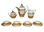 PORCELANA SCHMIDT, serviço para café com sete (7) peças, sendo: A) 1 bule para café, medindo 19x19x7cm, B) 1 açucareiro, medindo 10x12x6cm, C) 1 leiteira, medindo 12x12,5x6cm e D) 4 xícaras para café com seus respectivos pires, medindo 3,5x9x7cm, confeccionadas em porcelana nacional na tonalidade branca, decorada por espessa faixa em furtacor e na tonalidade bege, guirlanda floral e vegetalista em vasta douração, em excelente estado de conservação, pegas da tampa no feitio de meia lua.