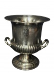 METAL PRATEADO, uma (1) champanheira confeccionada em metal espessurado a prata da manufatua BEL PRATA, bojo em gomos, alças laterais vazadas e base circular escalonada em martelados, medindo 26x23cm, pequena mossa na borda.