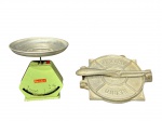 EQUIPAMENTOS PARA COZINHA, lote com duas (2) peças, sendo: A) 1 balança da manufatura BENDER, estrutura metálica esmaltada na tonalidade verde com prato em alumínio, sinais de oxidação, medindo 7x17cm e B) 1 prensa para tortilhas confeccionada em alumínio de origem mexicana, medindo 24x18,5cm.