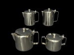 METAL INOX, parte de serviço para chá/café confeccionado em aço inox, sendo: A) 1 bule para café, medindo 13,5x14x9cm, B) 1 bule para chá, medindo 12,5x16x10cm, C) 1 leiteira com tampa, medindo 13x14x9cm e D) 1 açucareiro, medindo 9,5x14x9cm.