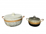 EQUIPAMENTOS DE COZINHA, duas (2) panelas confeccionadas em pedra sabão de tonalidades distintas, com guarnições e alças em cobre, maior medindo 17,5x34x26cm e menor 14x24x16cm. Ambas com sinais de uso.