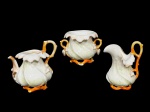 PORCELANA VIEUX PARIX, três (3) peças confeccionadas em porcelana na tonalidade branca, moldada em retorcidos, alça e base em galhos esmaltados na tonalidade abóbora e borda em folhagens, realçadas em ouro, sendo: A) 1 bule para chá sem tampa, colado na alça, medindo 14x13x9cm, B) 1 leiteira, colado na alça, medindo 13x10x8cm e C) 1 açucareiro sem tampa, medindo 9,5x12x9,5cm.