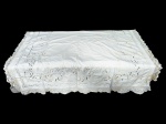 CAMA, MESA & BANHO, uma (1) toalha de mesa retangular, confeccionada em tecido branco, ricamente trabalhada com bordados Richelieu em vazados, aplicações rendadas e barra com acabamento em renda, medindo 232x166cm, apresenta manchas de guardado.