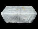 CAMA, MESA & BANHO, uma (1) toalha de mesa retangular, confeccionada em tecido branco, com bordado vazado em motivos florais e folhagens, barra recortada, apresenta manchas, vide foto, medindo 280x162cm.