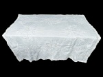 CAMA, MESA & BANHO, uma (1) toalha de mesa quadrada, em tecido branco, ricamente trabalhada com bordados Richelieu, com trechos de crivo ou rede nos vazados e decoração floral, apresentando barra com acabamento recortado, manchas e furos, no estado, medindo 132x132cm.