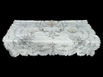 CAMA, MESA & BANHO, uma (1) toalha de mesa retangular da ILHA DA MADEIRA, em tecido branco, com bordado em linha escura, apresentando decoração floral, aves estilizadas, detalhes vazados e barra recortada. acompanhada de 3 guardanapos, apresenta manchas e pequenos furos, toalha medindo 220x169cm e guardanapos 40,5x40,5cm e 28,5x28,5cm.