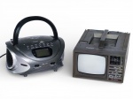 SOM e ELETRÔNICO, lote composto por dois (2) itens, sendo: A) um (1) rádio portátil TRC SOUND, modelo TRC-160 moderno, com alça superior, reprodução de CD, entradas USB / cartão de memória, visor digital e controles frontais, medindo 11,5x24x22cm e B) um (1) televisor portátil antigo da marca DELUXE, preto e branco, modelo compacto, com alça superior, seletores frontais, controles de sintonia, volume, brilho e contraste, característico da produção das décadas finais do século XX, medindo 13x20x26cm;