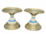 METAL PRATEADO e PORCELANA, par (2) de castiçais confeccionados em metal espessurado a prata, base escalonada, corpo em porcelana com espessa faixa na tonalidade azul e elementos florais em policromia, apresenta sinais de oxidação e fissura no metal, vide foto, medindo 13x13,5cm. Apresenta mossa na bobeche.