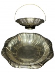 METAL PRATEADO, duas (2) fruteiras confeccionadas em metal espessurado a prata, sendo: A) 1 da manufatura REGIA, rico cinzelado floral em vazados e alça articulável, falhas na prateação, medindo 18x23cm e B) 1 cinzelada por faixas torcidas e ondulações na borda, apresenta falhas na prateção, medindo 5x25cm.