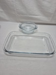 Lote de travessa retangular e travessa redonda com tampa em vidro temperado. Medindo a travessa 34,5cm x 21cm x 5cm de altura. Com leve bicado.