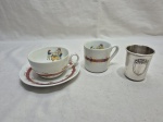 Lote infantil, composto de copo em prata 90, caneca e xícara em porcelana. Medindo o copo 6,5cm x 6,5cm de altura.