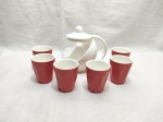 Lote de bule em vidro com suporte em metal e 6 copos em porcelana vermelha. Medindo o bule 15cm de altura.
