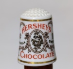 Dedal Porcelana Hershey's Chocolate Franklin Mint 1980 - Vintage Item original da série "The Country Store" da Franklin Mint, lançada em 1980. Miniatura em porcelana fina com bordas em dourado e publicidade clássica da Hershey's. Peça assinada e datada, em excelente estado de conservação, ideal para colecionadores de dedais e itens de publicidade antiga.