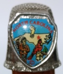 Dedal de Metal Colecionável Souvenir - North Carolina (Carolina do Norte)Escudo central colorido apresentando o mapa do estado, um cardeal-vermelho (pássaro oficial), a flor do estado (dogwood) e a figura de um nativo americano.