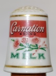 Dedal de Porcelana Vintage Carnation Milk - Franklin Mint 1980Apresenta o logotipo clássico da Carnation em vermelho e ilustrações detalhadas de flores (cravos) com a inscrição "MILK" em verde.