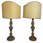 Par de antigas luminárias de mesa e ou abajures, bases em madeira nobre entalhadas em florões com patina em ouro velho que ostentam mangas no formato meia lua. Possui fiação. Mede 73 cm altura.