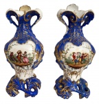 SÉCULO XVIII - Par de magníficas ânforas em porcelana francesa de SÈVRES, fartamente adornadas com cena do cotidiano com figuras humanas, rica policromia e folhas de acanto na totalidade azul real com filetes de ouro Meados século XVIII. Mede 35cm.