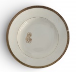 LOUÇA DO IMPÉRIO - Prato fundo em pasta de porcelana francesa LIMOGES adornado com friso em vibrante ouro e monograma do arquiteto, pintor e capitão JOAQUIM CÂNDIDO GUILHOBEL (Lisboa, 1787 - Rio de Janeiro, 1859). Louça da aristocracia do Império Brasileiro. Possui discreto bicado. Mede 25cm.