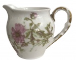FRANÇA - Leiteira / cremeira em porcelana francesa, decoração floral policromada em delicados tons rosados e verdes, acabamento com filetes dourados na alça. Marca D & C  France na base. Peça elegante, ideal para compor serviços de chá ou café.Estado de conservação: bom, com sinais naturais do tempo. Mede 14 cm.