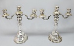 Par de antigos candelabros para três velas em metal folheado a prata, cinzelado com volutas e pardrões florais. Desgastes bo banho. Med.36 cm