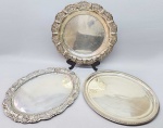 Três travessas, sendo duas ovais e uma redonda, em metal banhado a prata. Sem marca. As duas maiores medem:  40 cm