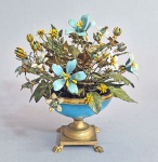 Jane Hutcheson for Gorham - Escultura no formato de cesta de flores em metal dourado e esmaltados a mão. Bojo em vidro opalinado azul ( vidro no estado). Item com altas cotações internacionais.  ------ https://www.1stdibs.com/furniture/decorative-objects/sculptures/figurative-sculptures/jane-hutcheson-gorham-enamel-flowers-fleurs-des-siecles-circa-1970s/id-f_48252592/  ---- https://www.chairish.com/product/32004509/jane-hutcheson-for-gorham-enamel-flowers-fleurs-des-siecles-circa-1970s  ----- https://www.ascasonline.org/articolodicem105.html
