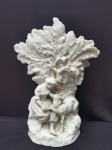 Vileteiro em porcelana branca vitrificada, com cena campestre em alto-relevo representando figura feminina e cordeiro sob árvore volumosa, base naturalista com detalhes de douração, medindo 21 cm de altura por 15 cm de largura, peça decorativa de estilo clássico europeu, apresentando leves sinais do tempo conforme fotos. CONFORME FOTOS